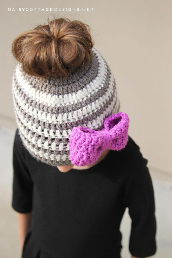 Learn how to make this adorable messy bun hat crochet pattern for kids! It's quick and easy, and will be sure to put a smile on any little girl's face! 