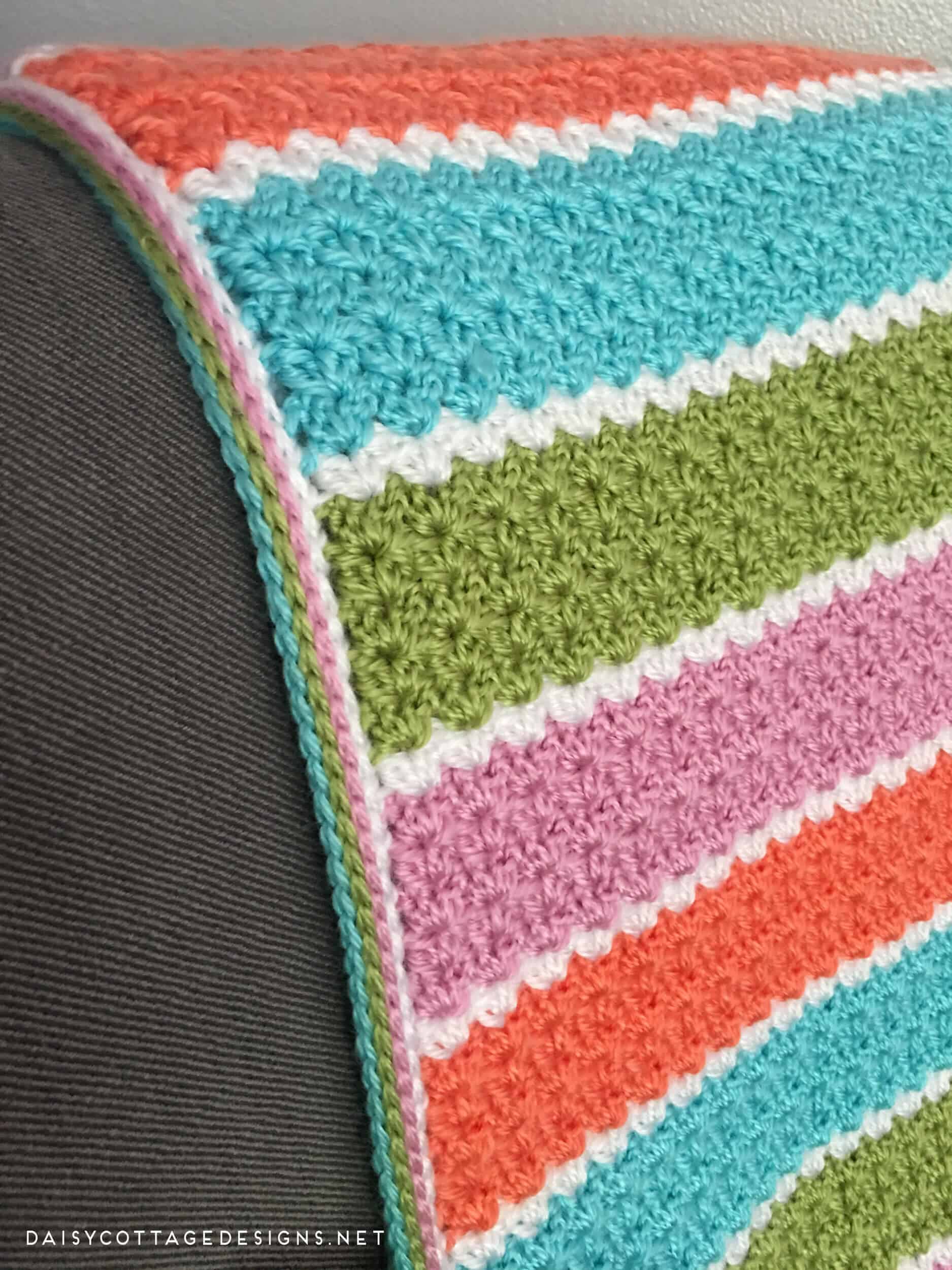 If you're looking for a free crochet blanket pattern that works up quickly, this easy v-stitch blanket from Daisy Cottage Designs is the way to go! | free crochet pattern, easy crochet blanket pattern, striped baby blanket pattern