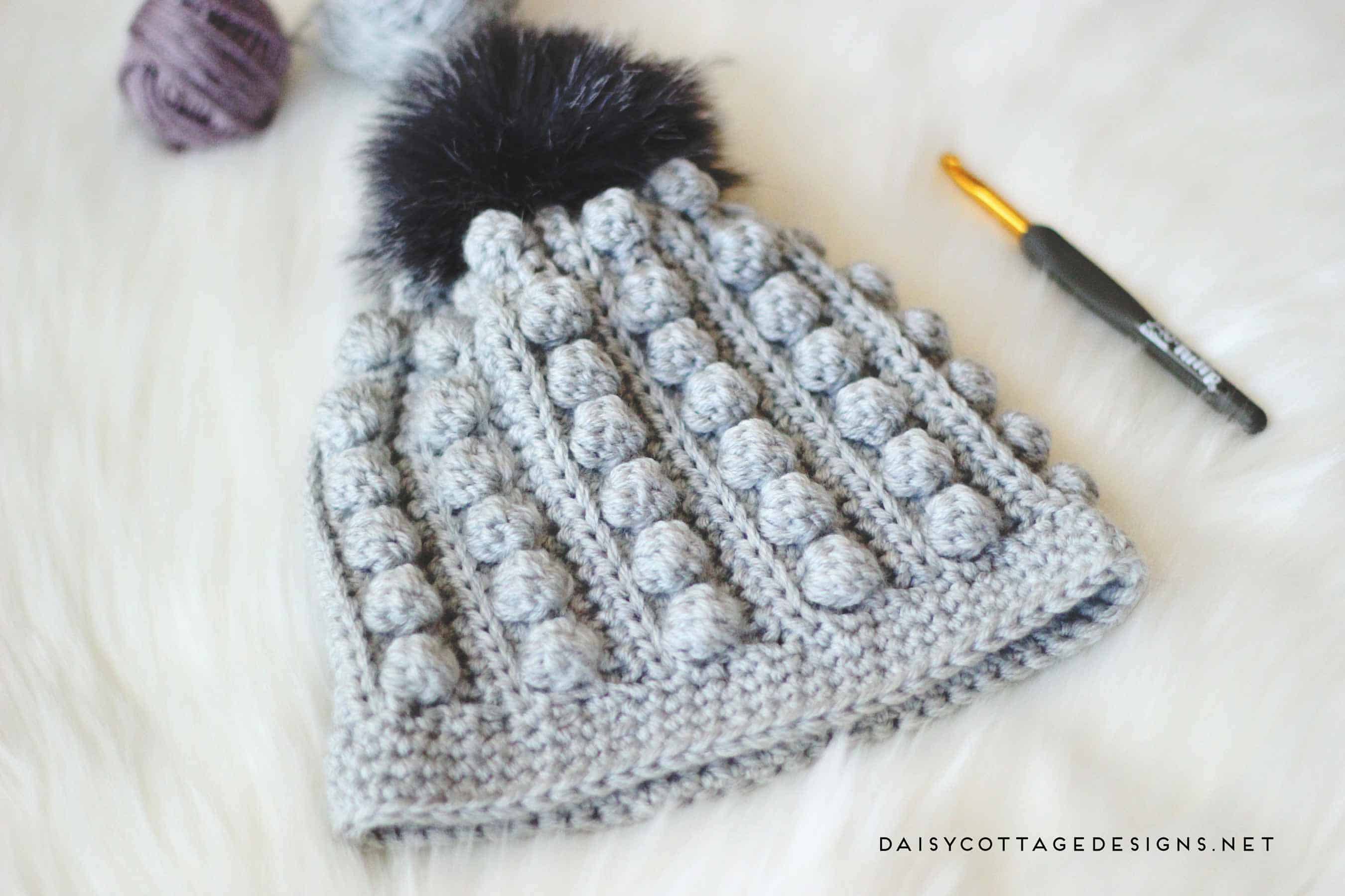 Use this free bobble beanie crochet pattern to create an adorable crochet hat for anyone on your gift list. Cozy and warm, it's the perfect winter hat. | bobble toboggan, Daisy Cottage Designs, free crochet pattern, free hat crochet pattern, crochet hat pattern free, bobble beanie