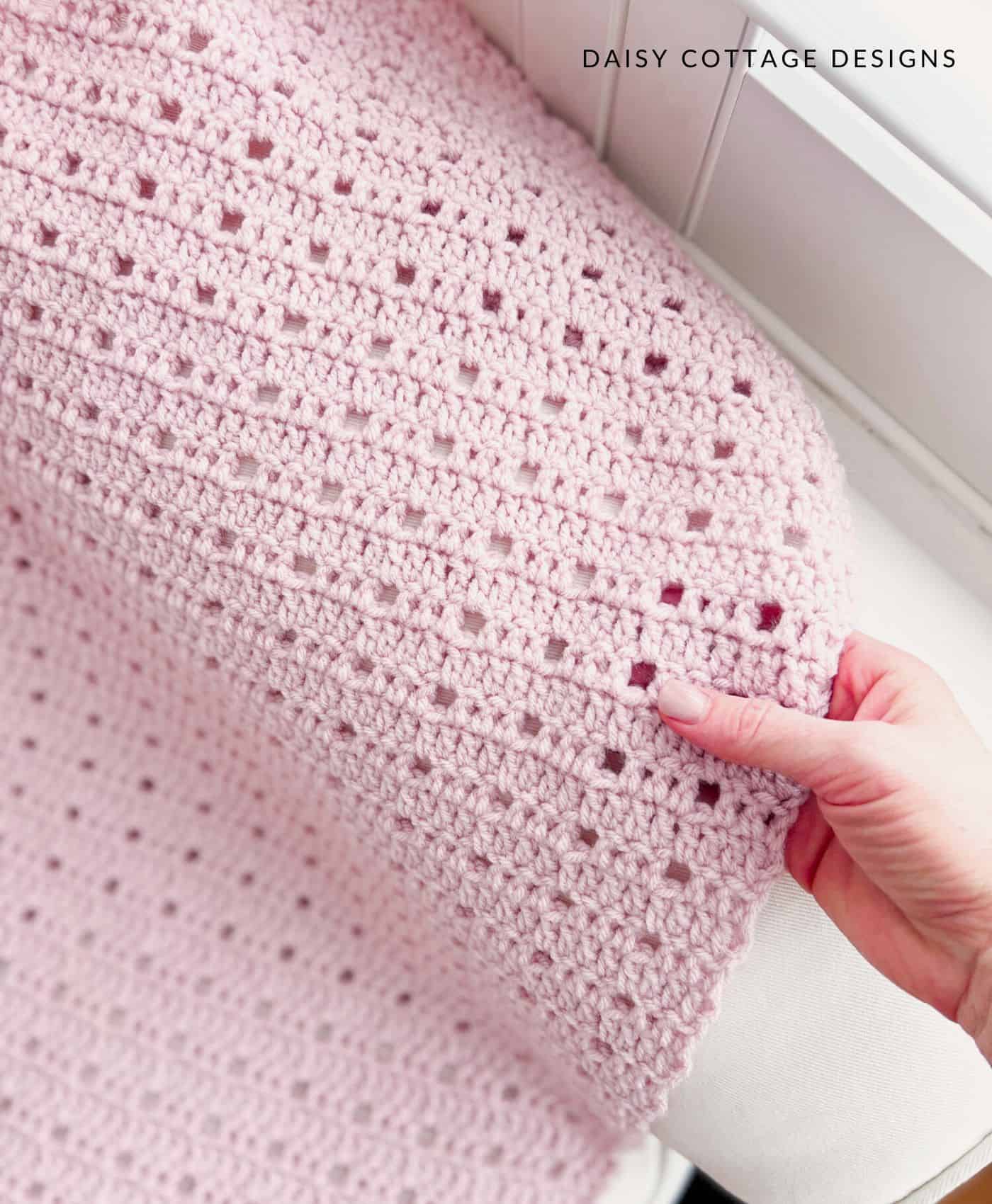 woman's hand and crochet baby blanket 