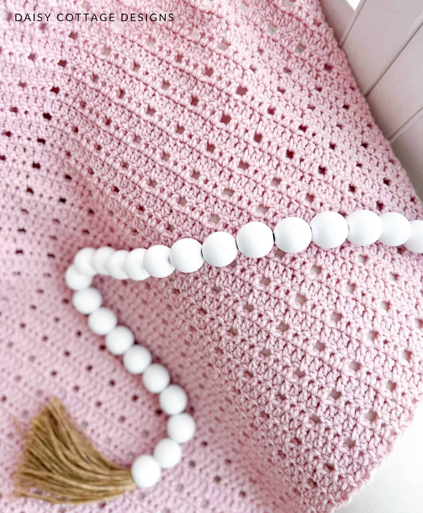 White beads and simple pink crochet baby blanket