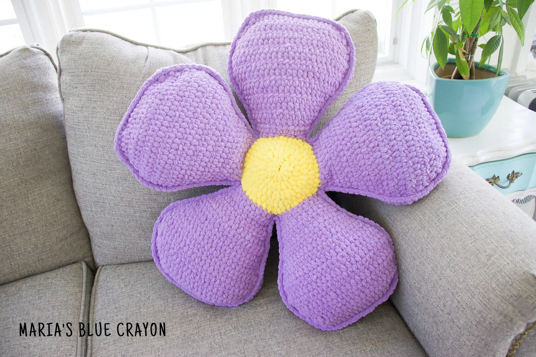 Crochet flower pillow in purple and yellow