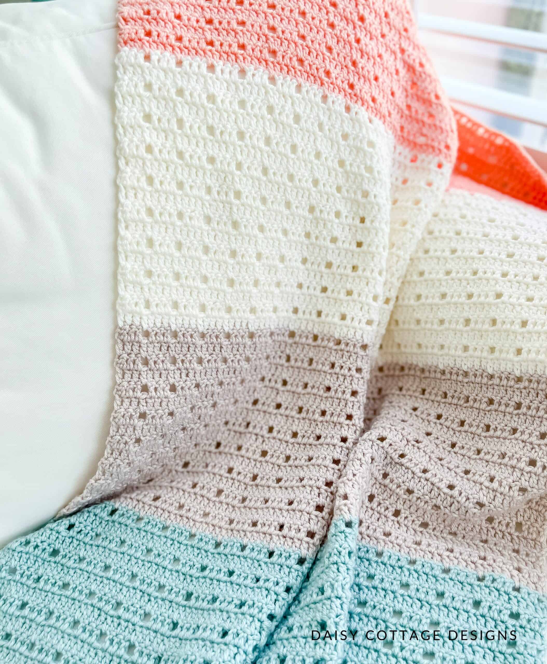 Colorful crochet blanket draped over a couch