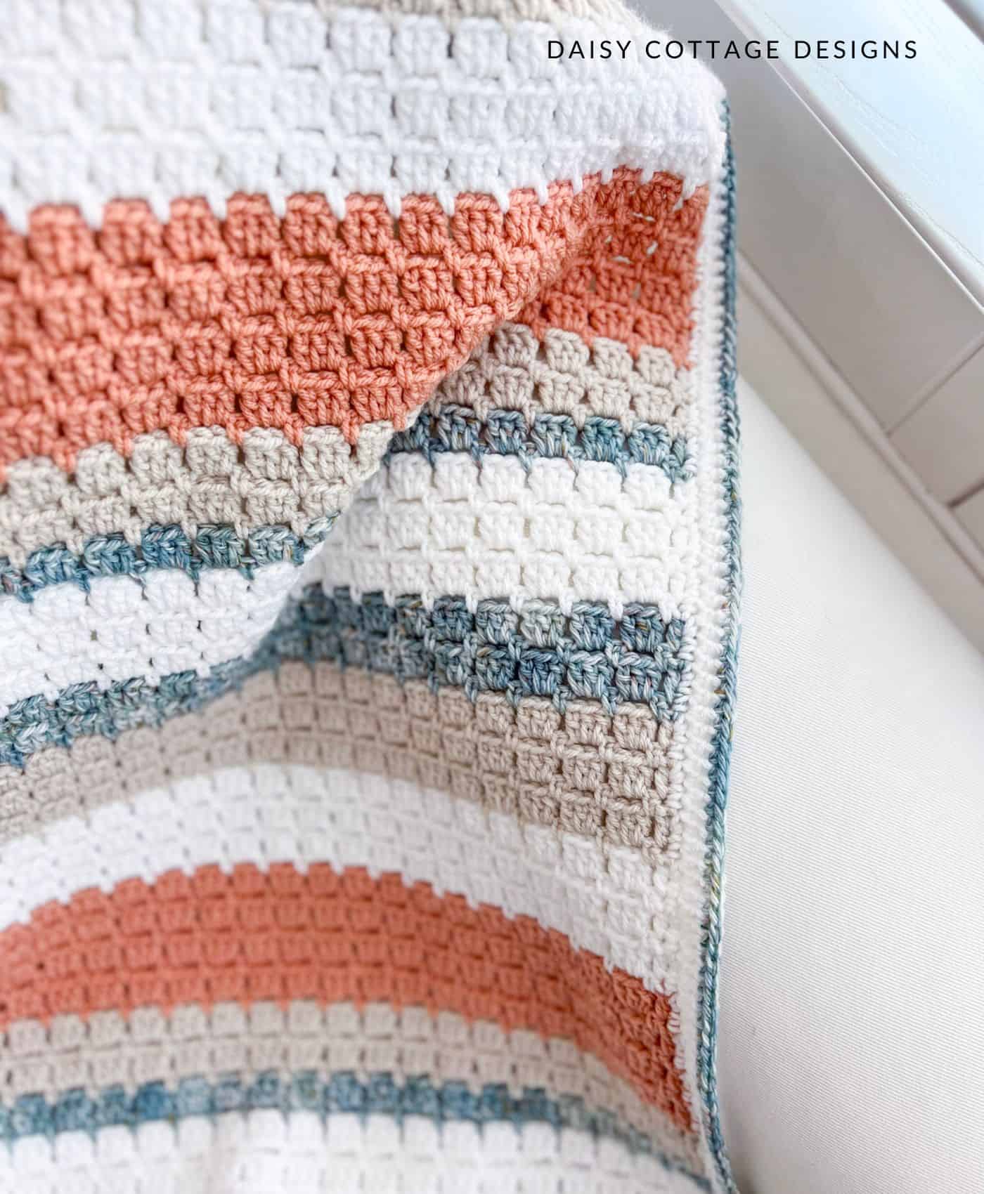 Block stitch crochet blanket on a white couch