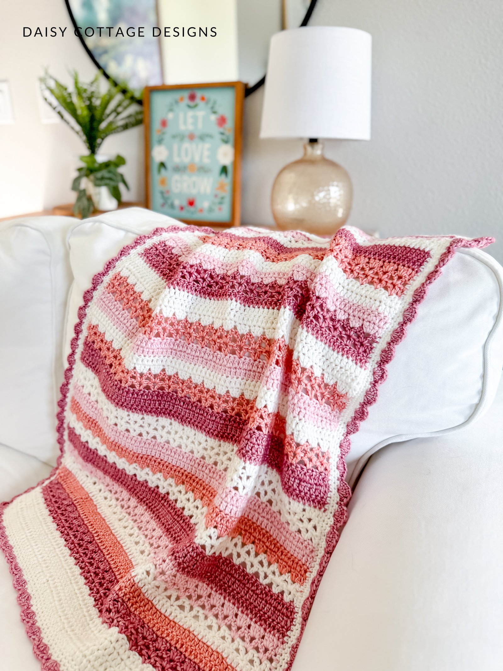 striped crochet blanket with scalloped border on a white couch